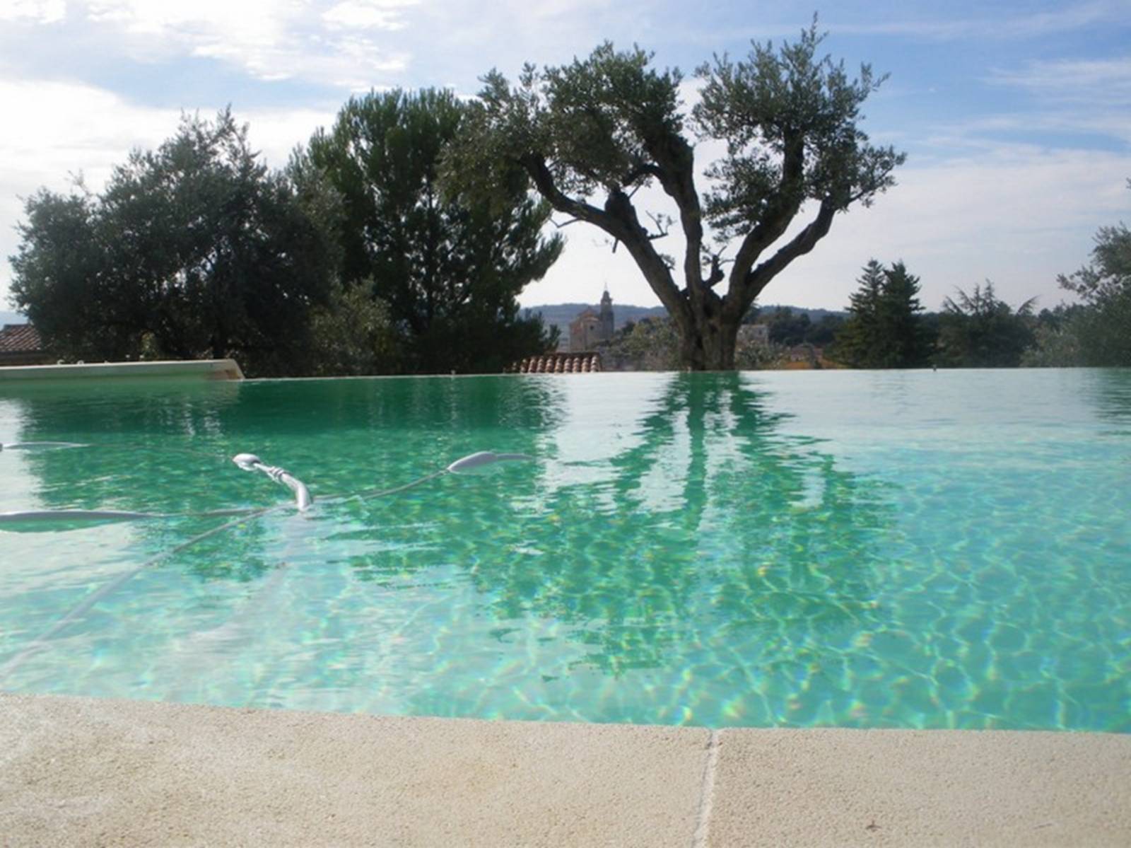 Construction d’une piscine à débordement en PVC armé beige à Bédoin pour une eau couleur lagon parfaitement intégrée aux paysages du Mont Ventoux